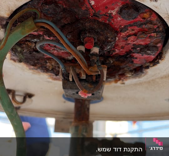 חלק תחתון של דוד שמש עם חיבורים וחלודה